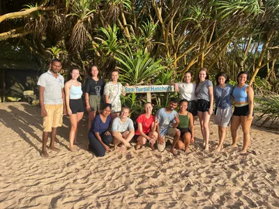 Group of volunteers on the beach in front of a sea turtle hatchery sign