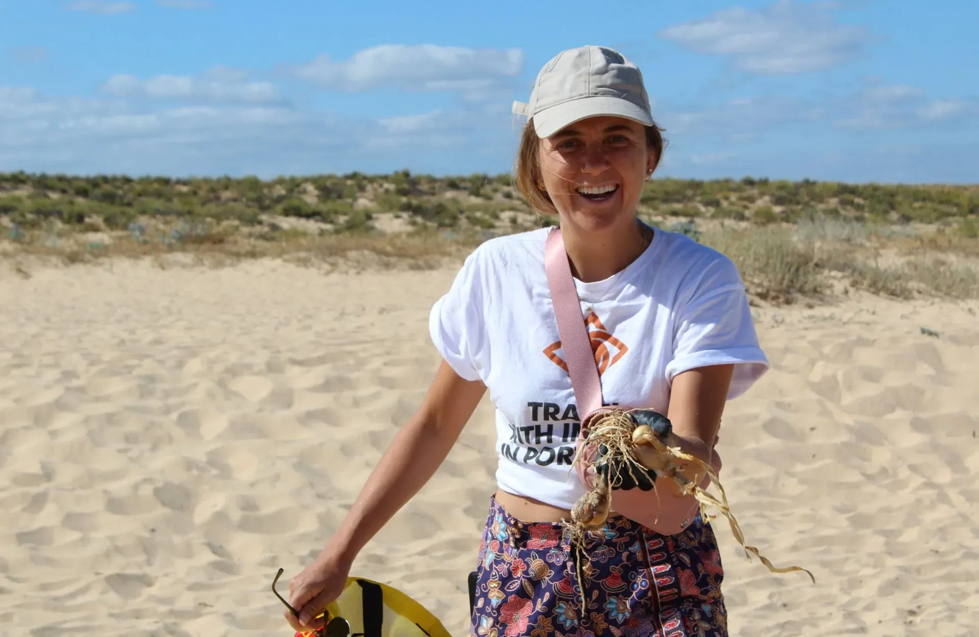 Smiling volunteer on a sandy beach during a conservation activity