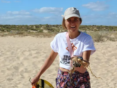 Smiling volunteer on a sandy beach during a conservation activity