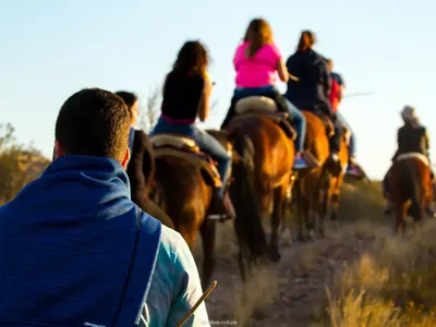 Riders on horseback following a trail at sunset near Mendoza, Argentina