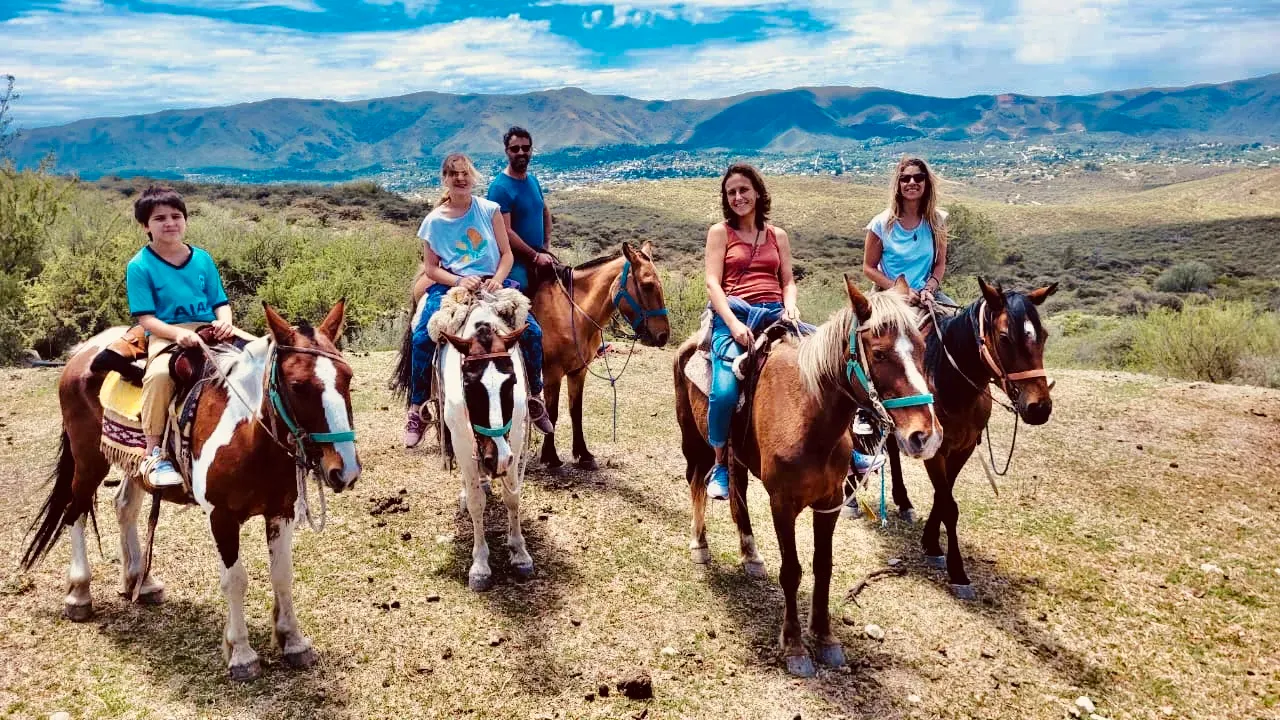 Small group of travellers horse riding in the hills of Argentina