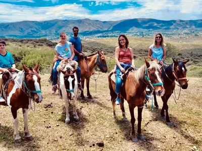 Small group of travellers horse riding in the hills of Argentina