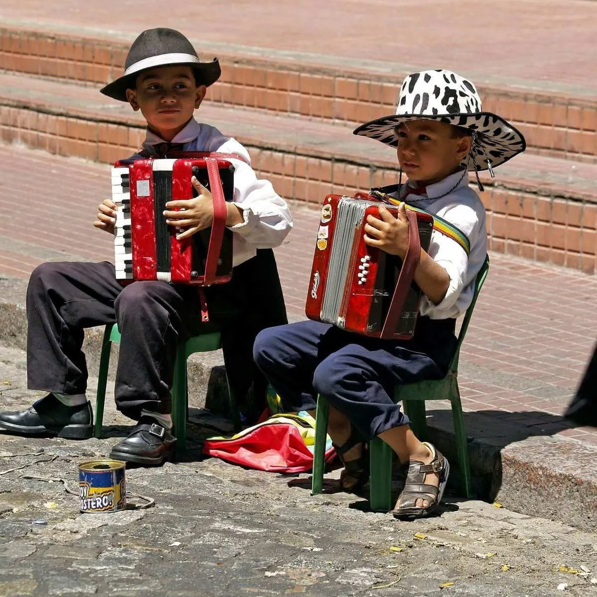 Two boys in hats playing the accordion in the street in Argentina