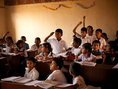 Pupils raising their hands in a classroom in Kerala, India
