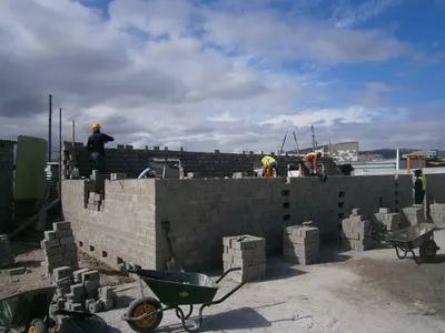 Workers building breeze-block walls on a construction site in Cape Town