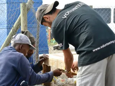 Volunteer working alongside local craftsmen in a workshop in South Africa