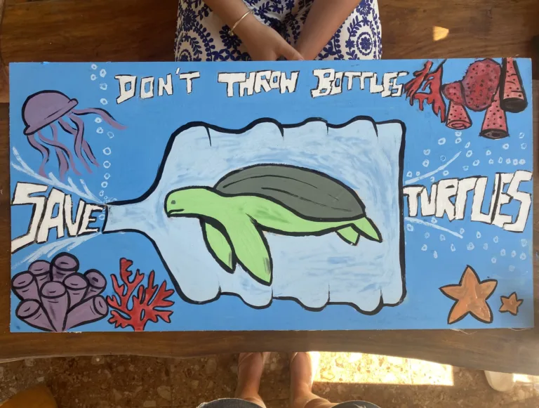 Une pancarte peinte invite à protéger les tortues et à ne pas jeter de bouteilles.